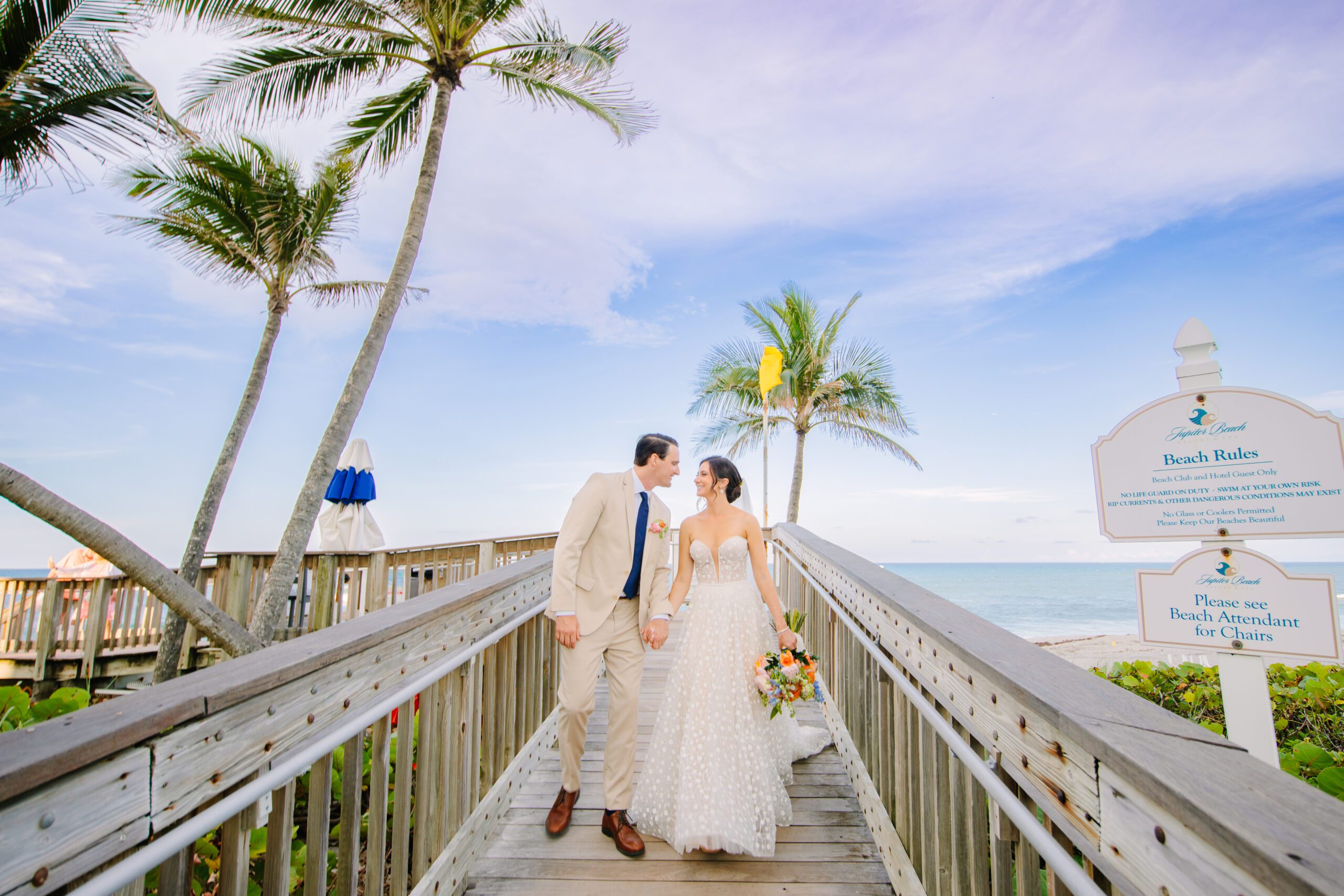 couple walking on boardwalk at their Jupiter Beach Resort wedding